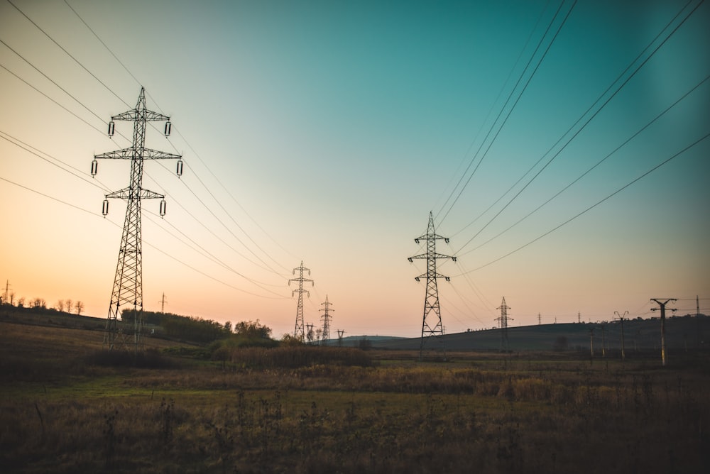 fotografia de paisagem de torres elétricas sob um céu azul calmo