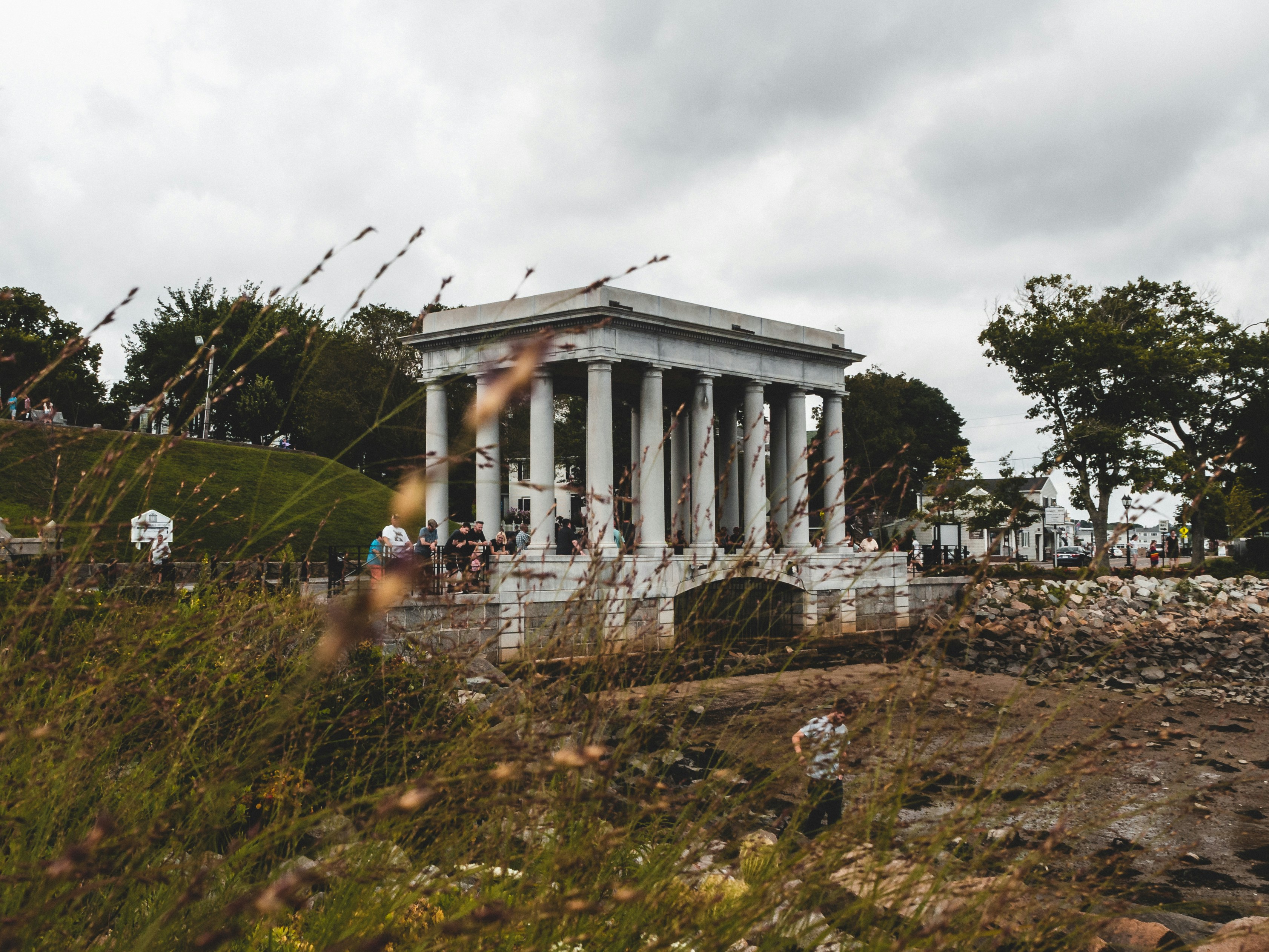 white concrete building surrounded with trees during daytime plymouth rock teams background