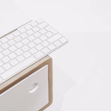 Close-up of hands typing on a keyboard with a clean desk setup.