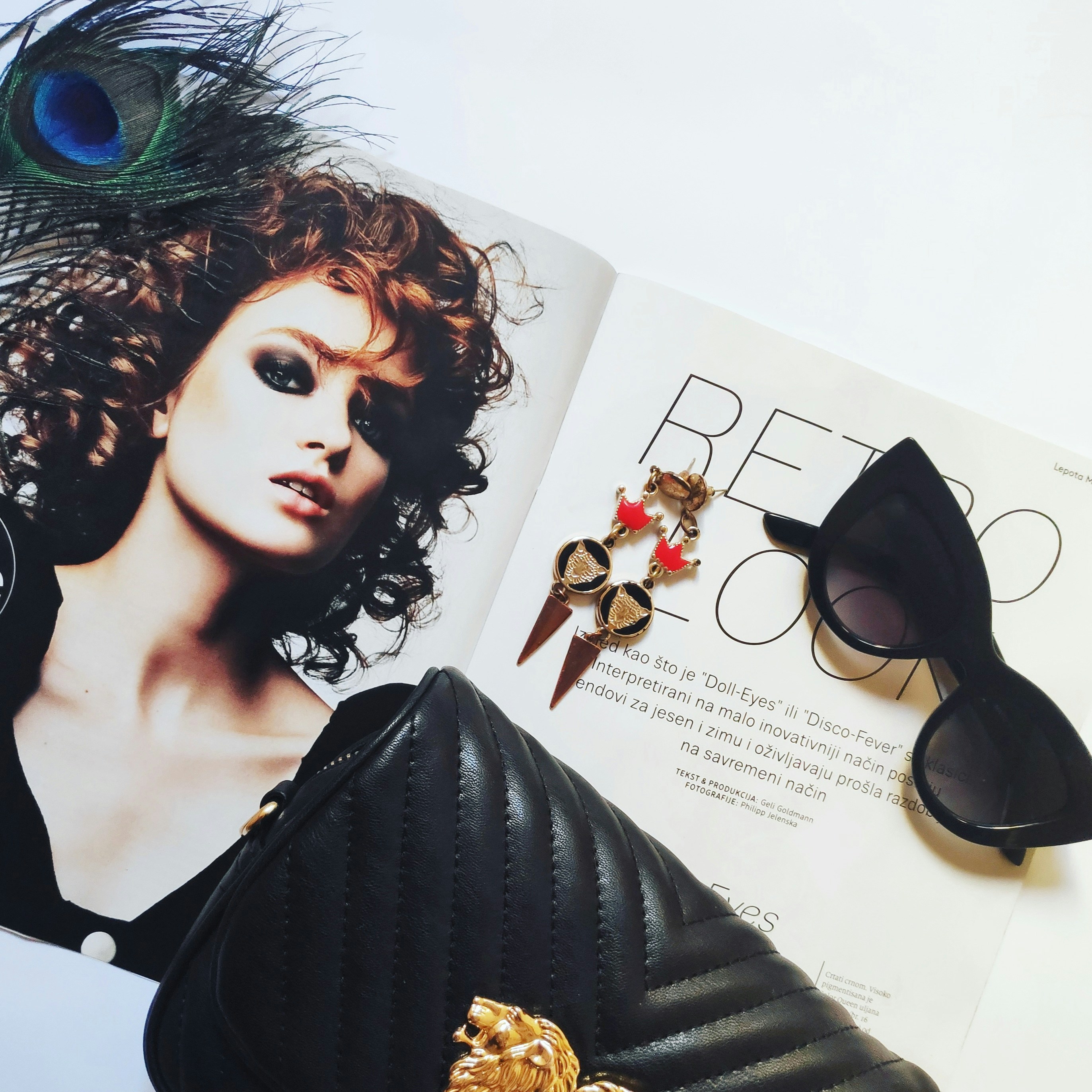black leather clutch bag and black framed black lens sunglasses