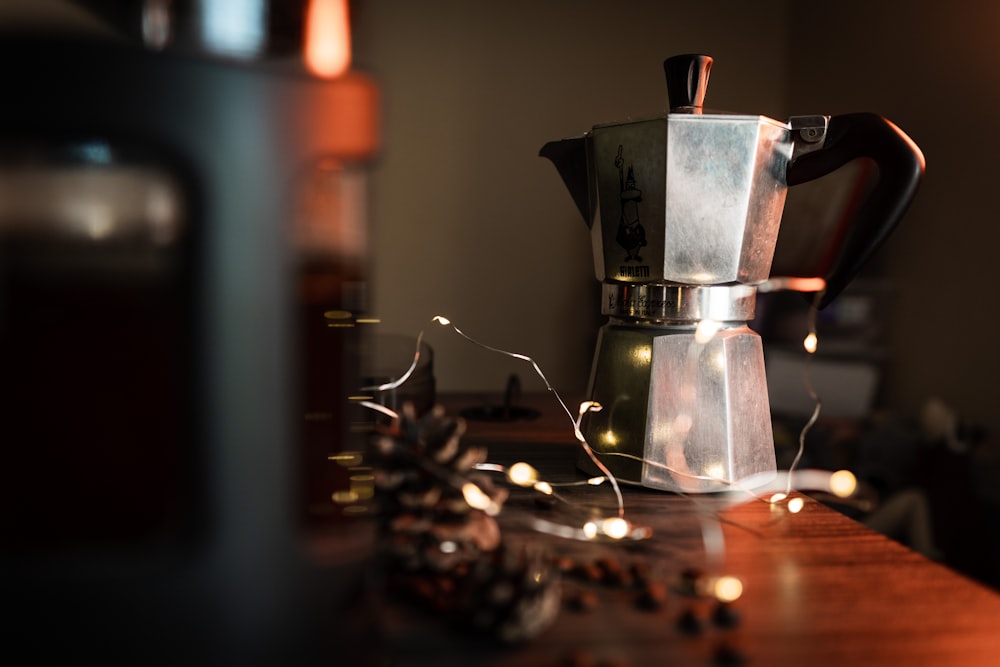 grey stainless steel moka pot on brown wooden surface