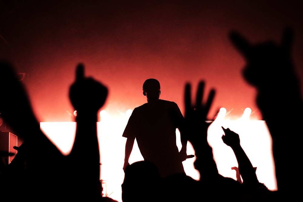 silhouette of man on stage holding microphone