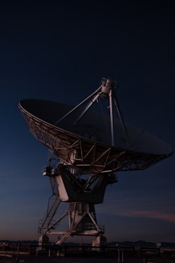 A sleek satellite dish against a twilight sky symbolizing advanced aerospace communication.