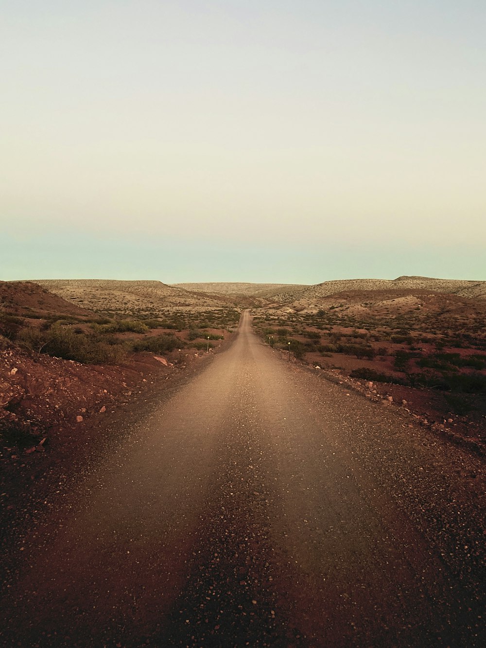 Camino de tierra marrón con montañas a la distancia