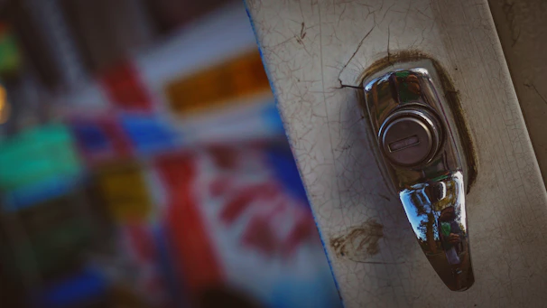 A close-up of a broken doorknob on an old wooden door, symbolizing the unexpected disruptions in Clancy’s life.