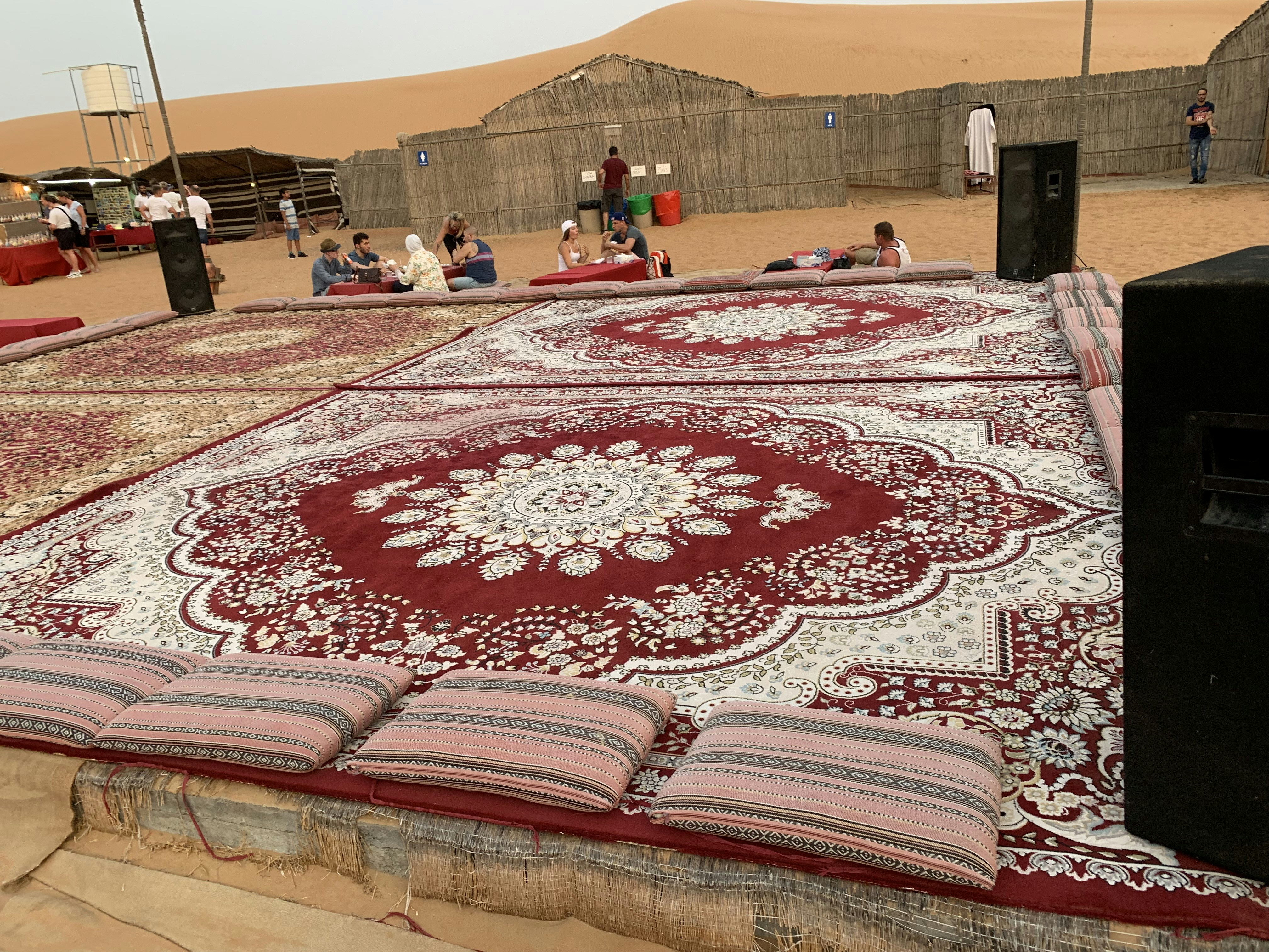 Traditional Bedouin camp setup with carpets and cushions in desert