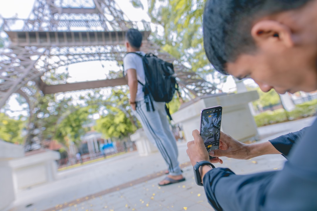 man taking picture of man carrying backpack