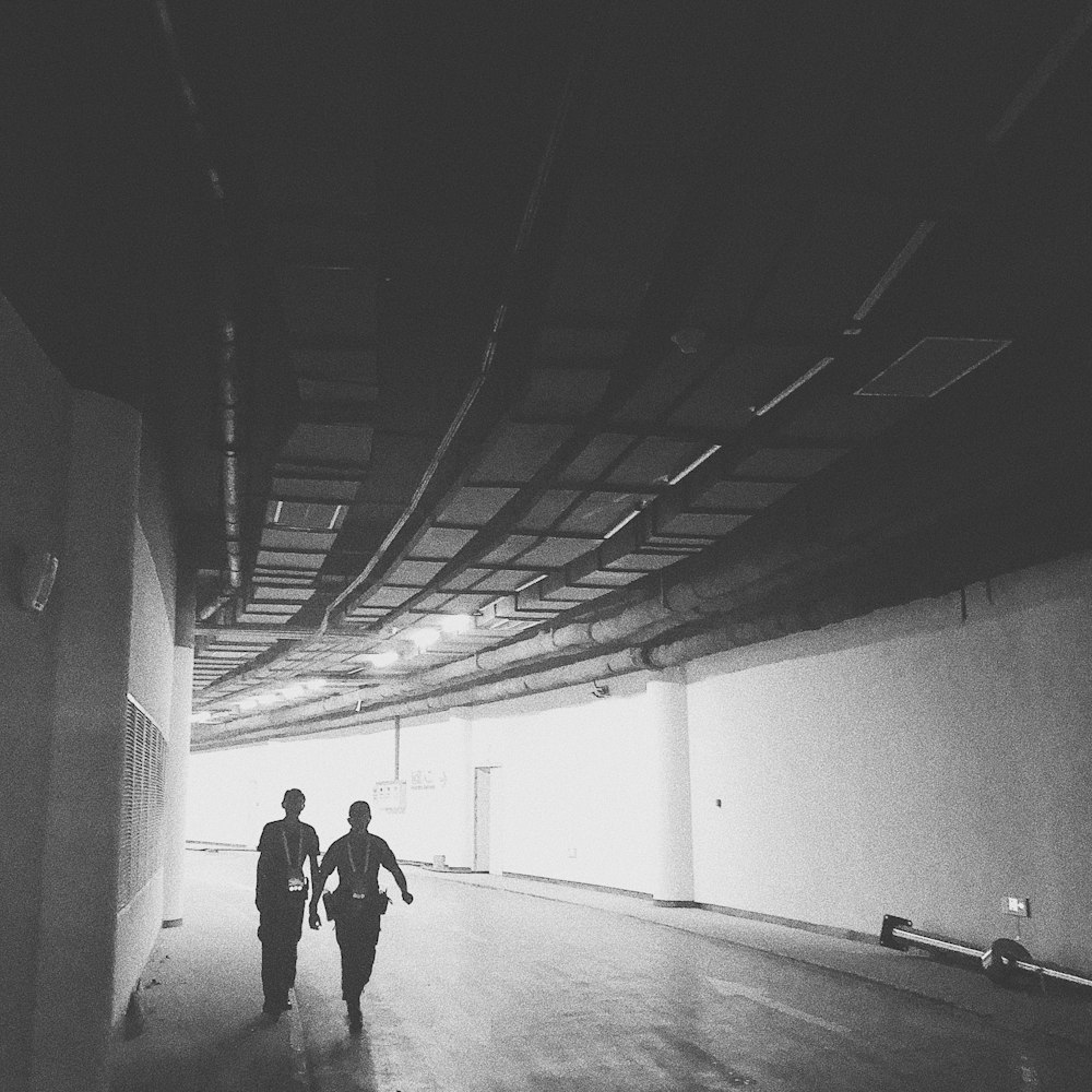 two men walks inside tunnel