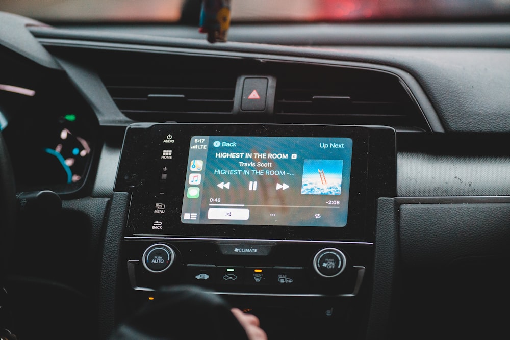 black touchscreen car stereo displaying music playlist