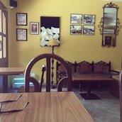 The cozy interior of RS Mani Cafe featuring warm brown and yellow decor with wooden furniture.