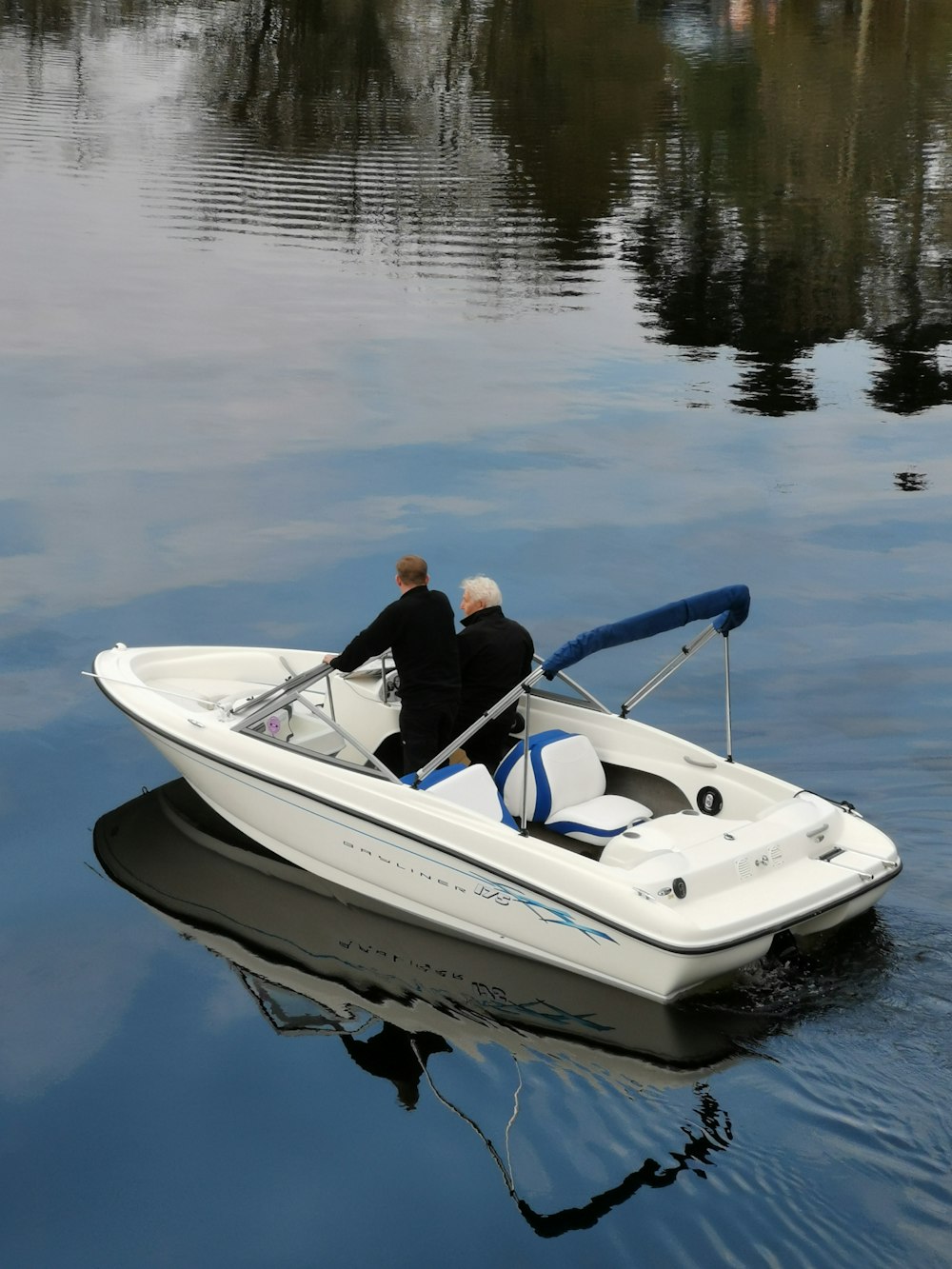 man wearing black long-sleeved shirt on white sailboat