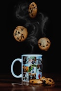ceramic mug on brown surface with cookies
