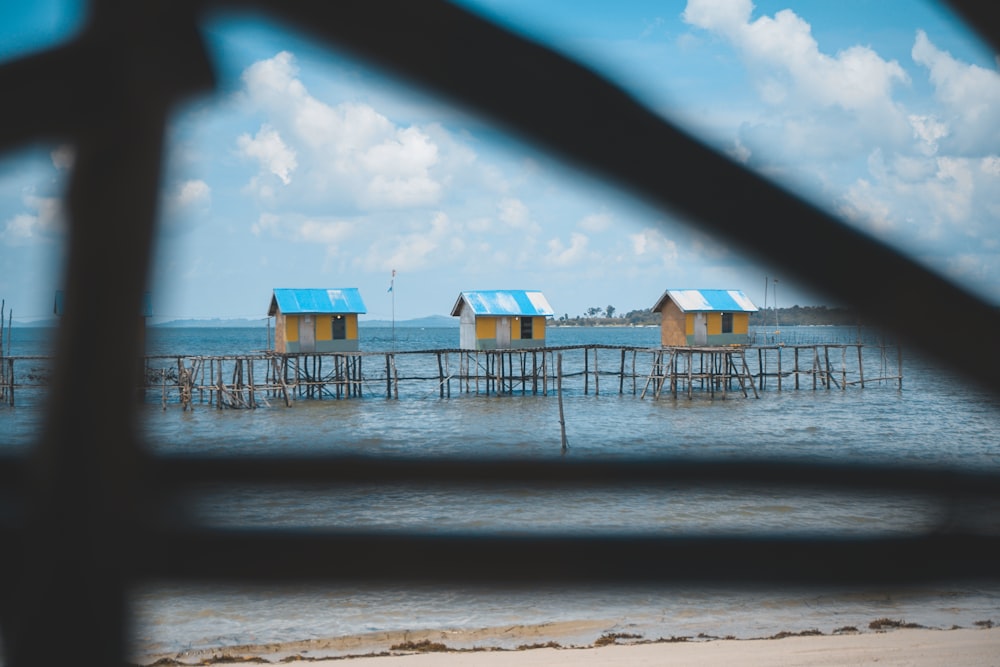 brown-white-and-blue nipa huts over body of water