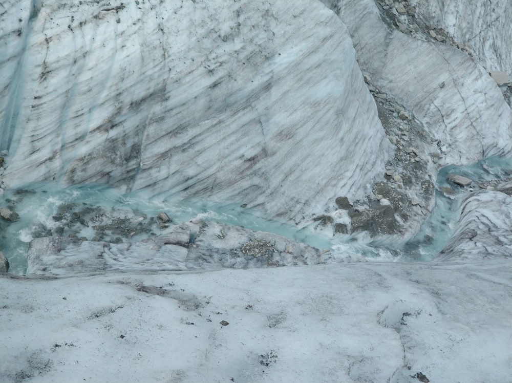 a man standing on a snow covered slope next to a river