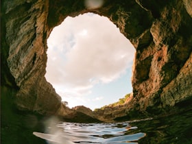 O buraco de uma caverna mostrando nuvens no céu