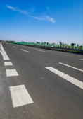 Wide shot of a newly rehabilitated highway with clear lane markings and safety barriers.