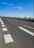 Image showing a freshly paved highway with clear markings under a bright sky.