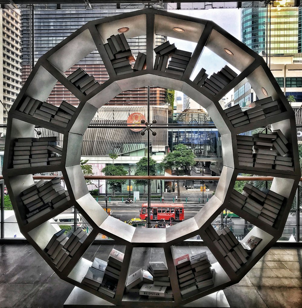 different books in round white wooden bookshelf