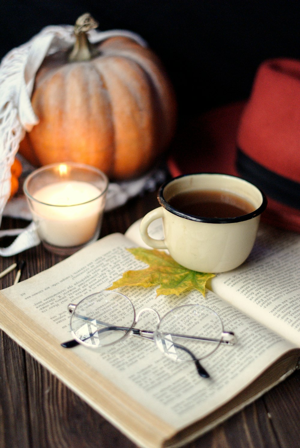 cup of tea and eyeglasses on top of book