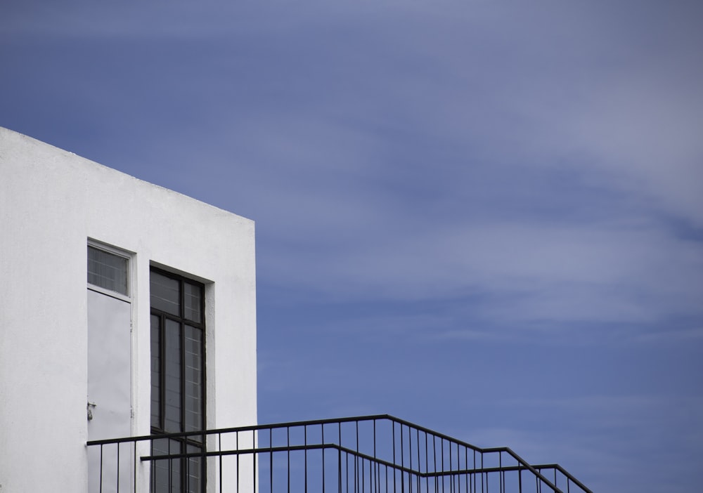 white building with black staircase under blue sky