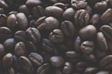 Close-up of freshly roasted coffee beans on a wooden surface.
