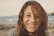 woman smiling wearing grey knit top