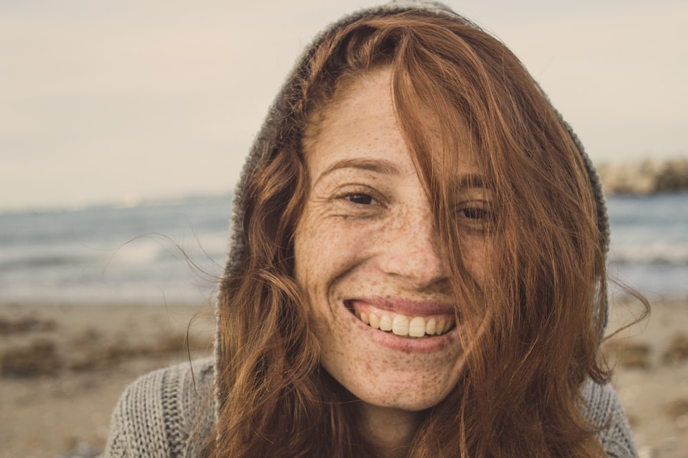 woman smiling wearing grey knit top