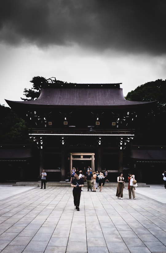 people walking beside gateway in Meiji Jingu Japan