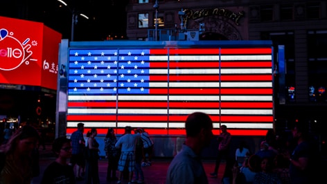 people walking beside LED flag of America