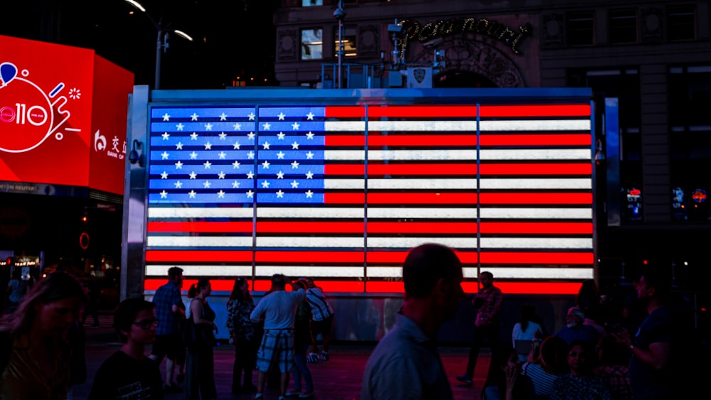 people walking beside LED flag of America