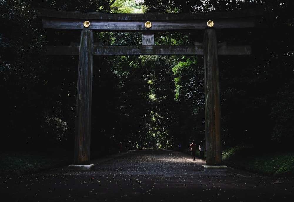 brown wooden gate on road under trees