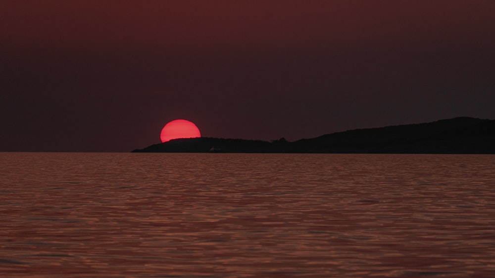 body of water viewing mountain during sunset