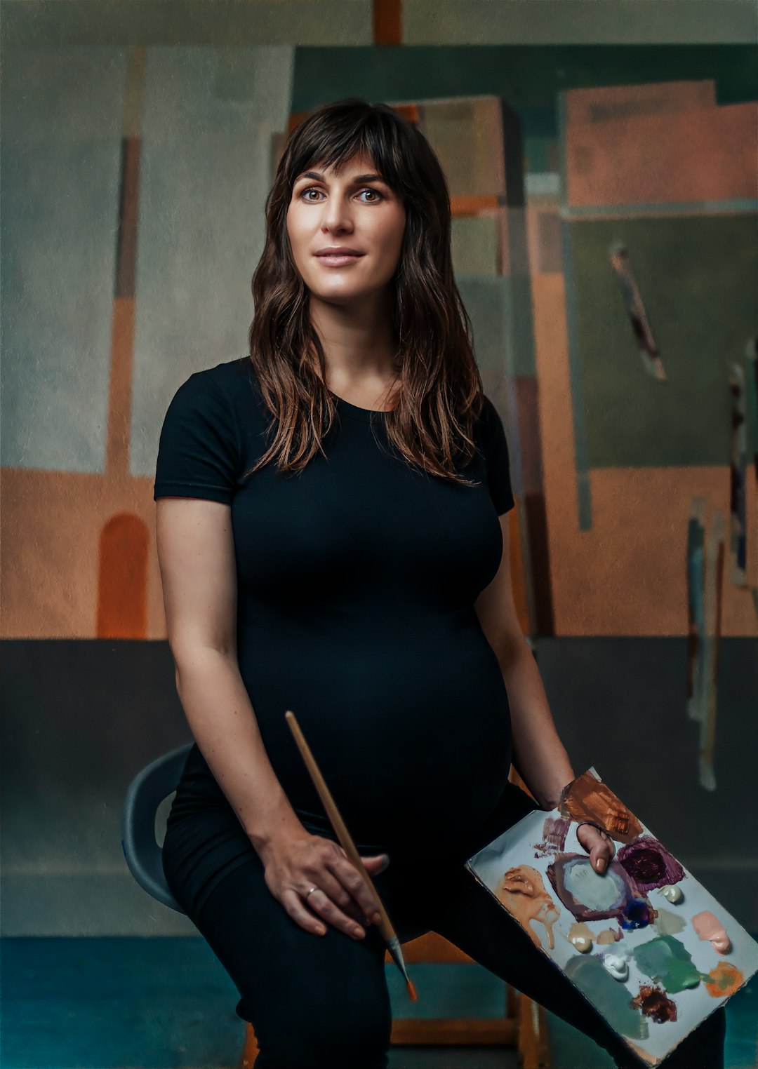 woman wearing black blouse holding brown paint brush