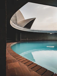 Sleek rectangular pool with clean lines, smooth concrete deck, and a sculptural fountain.