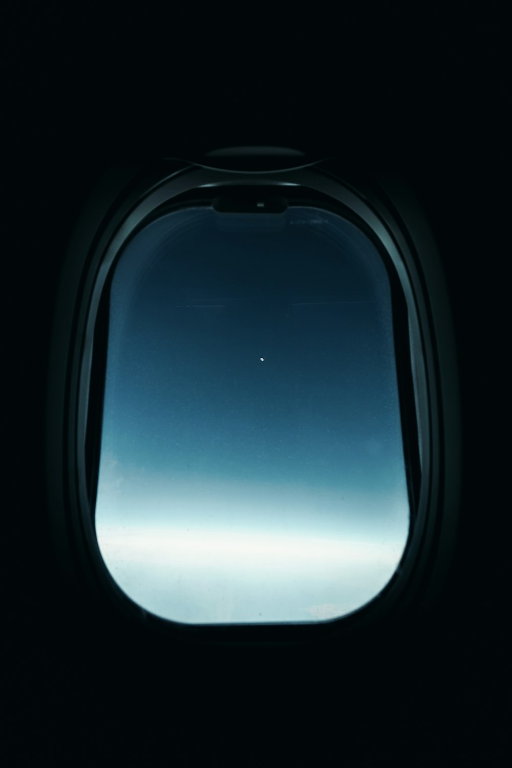 an airplane window with a view of the sky