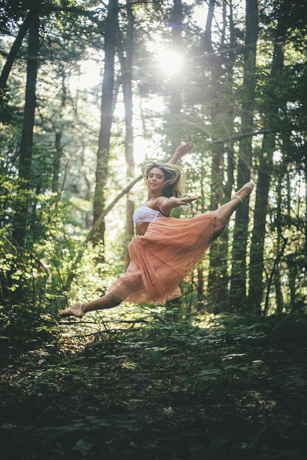 woman jumping surrounded by trees