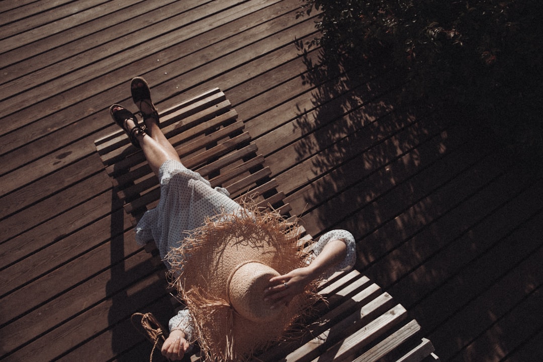 woman in white dress sitting on brown chair outdoors