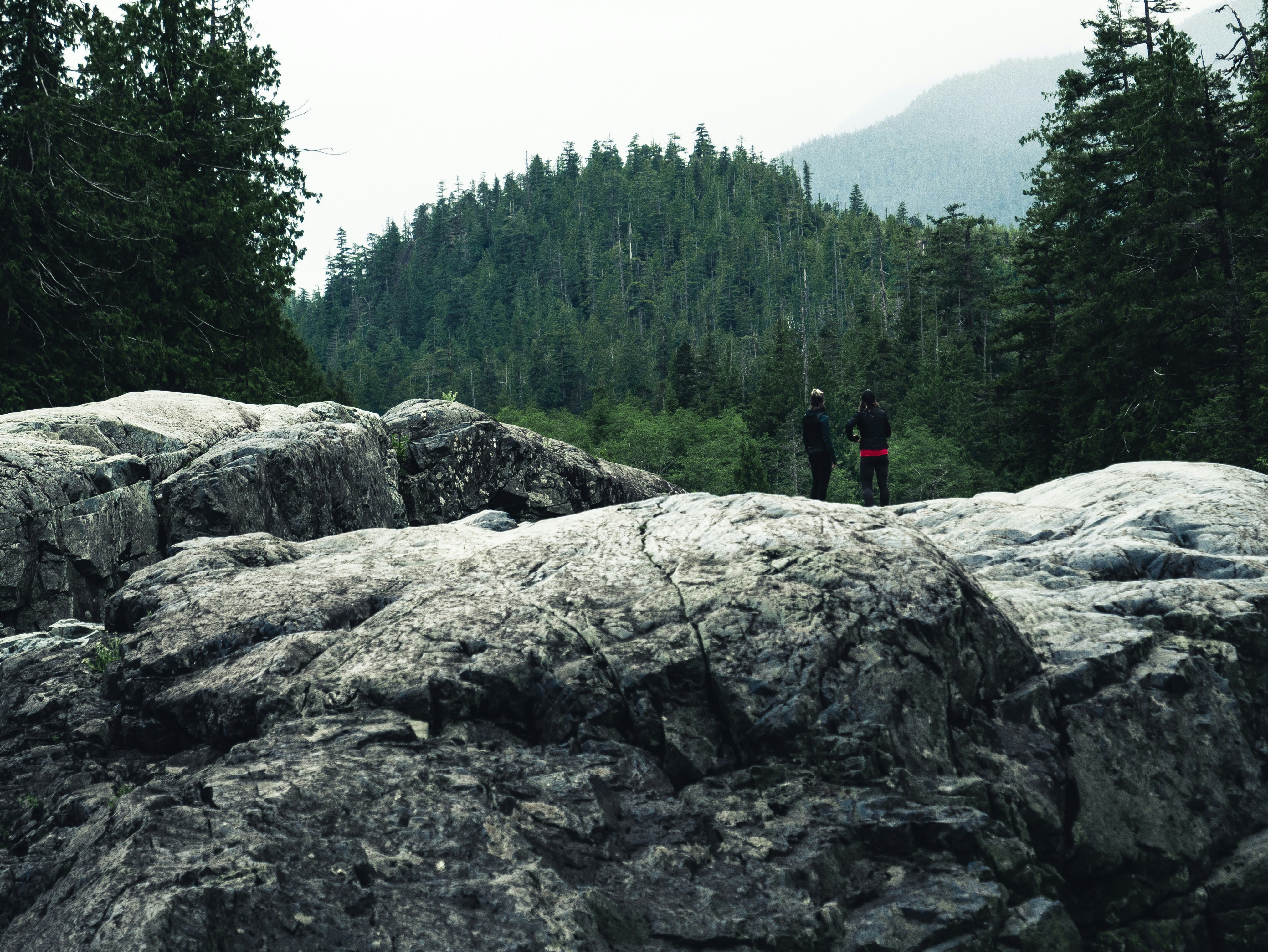 two person standing on rock formation