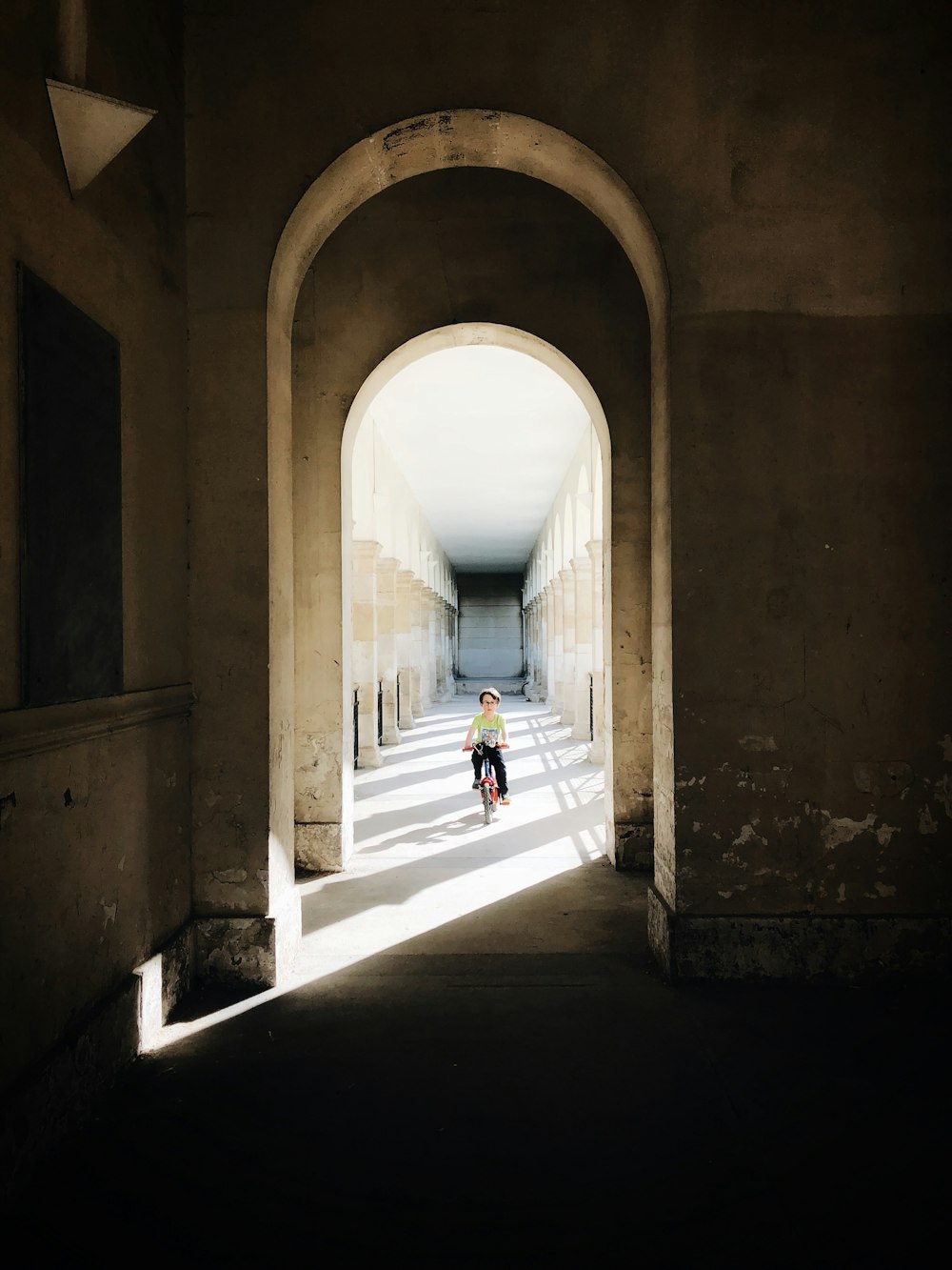 boy riding on bike riding on corridor