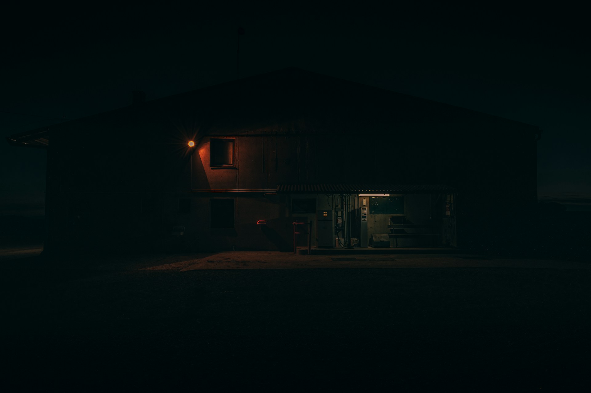 a dark house with a light on at night