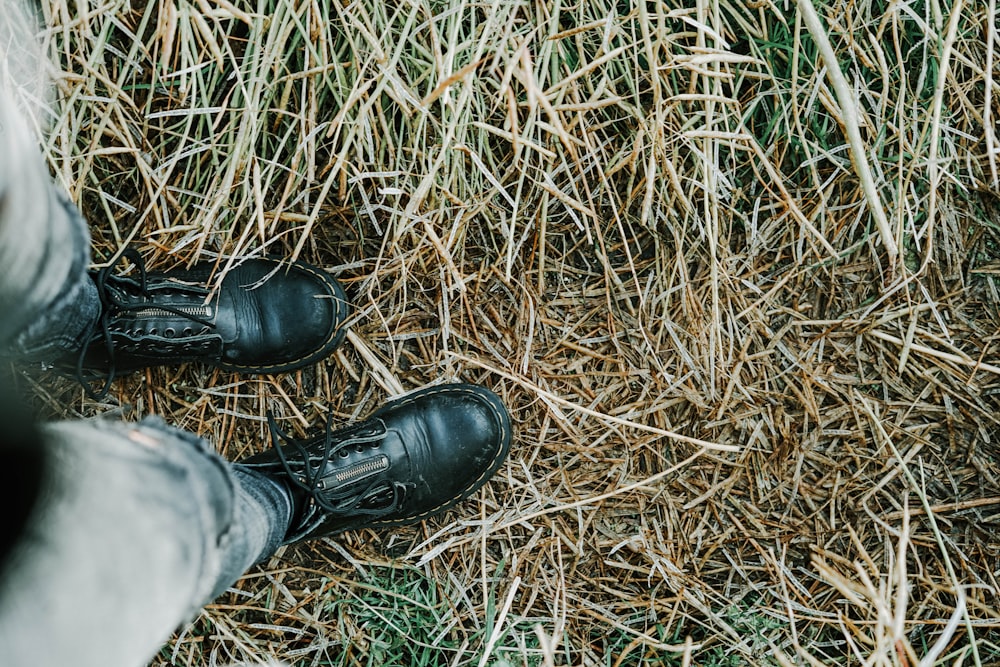 person in black leather lace-up shoes