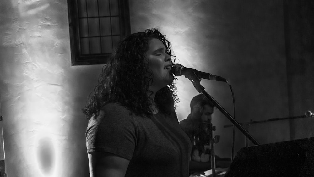 grayscale photography of woman singing
