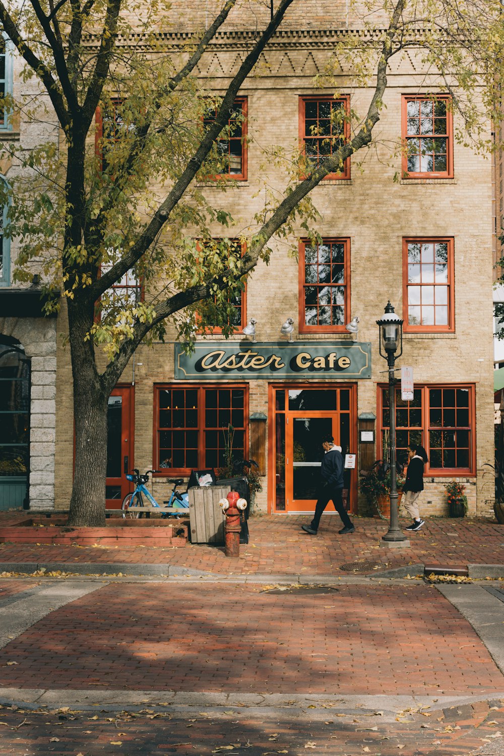 man walking in front of aster Cafe