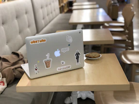 A friendly craftsman explaining cookie settings on a laptop in a cozy workshop.