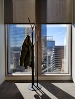 Side view of a tailored coat catching the wind on an urban rooftop at sunset.