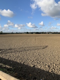 A freshly plowed field ready for planting under a bright sky.