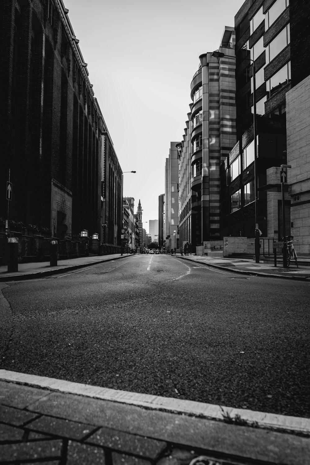 grayscale photography of a street between buildings