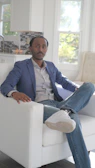 A stylish navy blazer draped over a modern chair in a bright room.