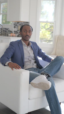 A stylish navy blazer draped over a modern chair in a bright room.