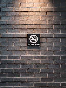 no smoking sign on brick wall